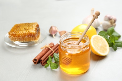 Photo of Honey, cinnamon and other fresh products on grey table. Natural antibiotics