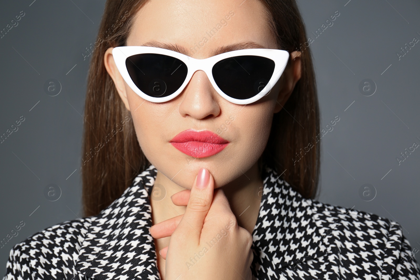 Photo of Young woman wearing stylish sunglasses on grey background