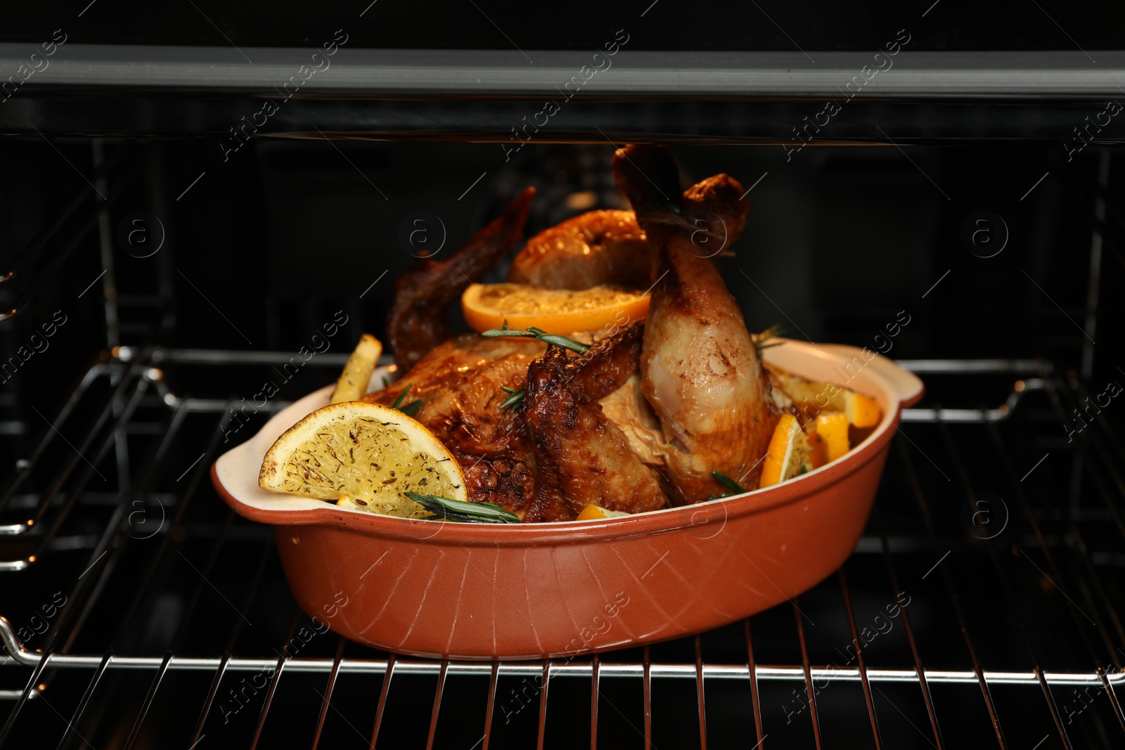 Photo of Chicken with orange slices baking in oven