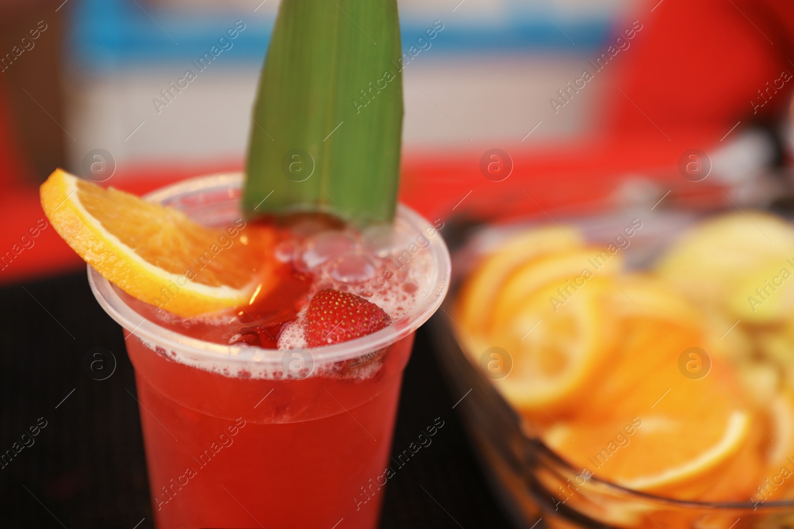 Photo of Delicious refreshing drink in plastic cup on bar counter, closeup