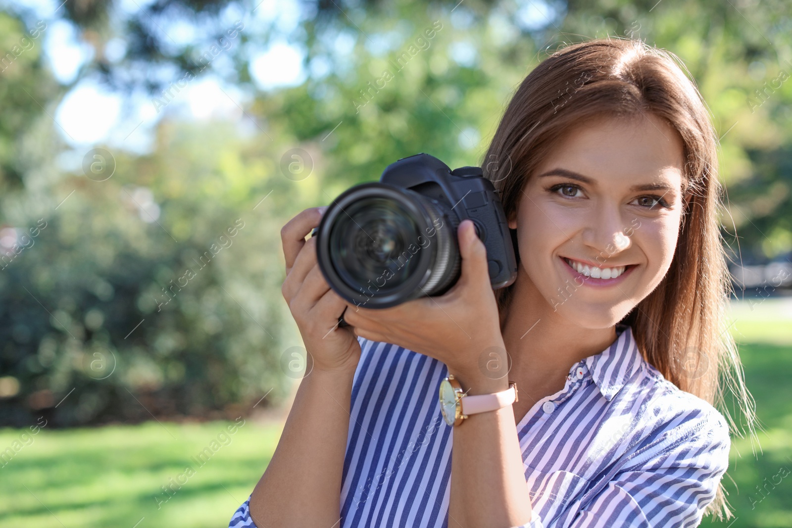 Photo of Young female photographer with professional camera in park. Space for text