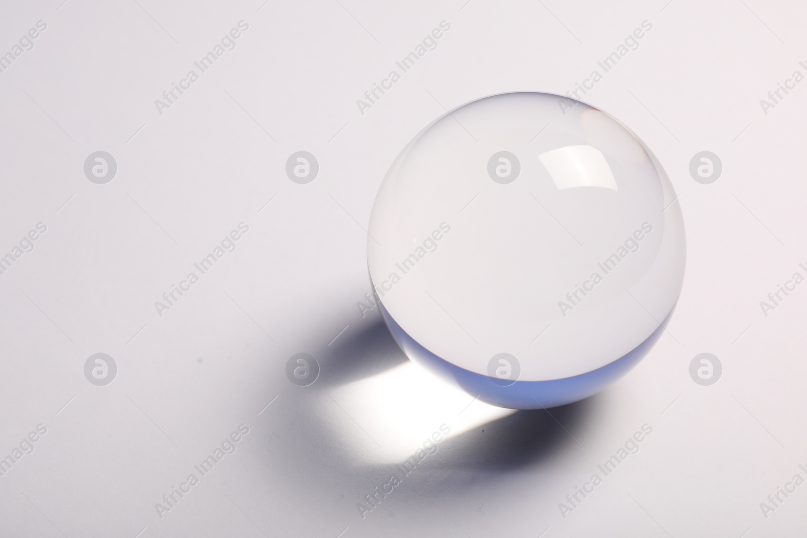 Photo of Transparent glass ball on white background. Space for text