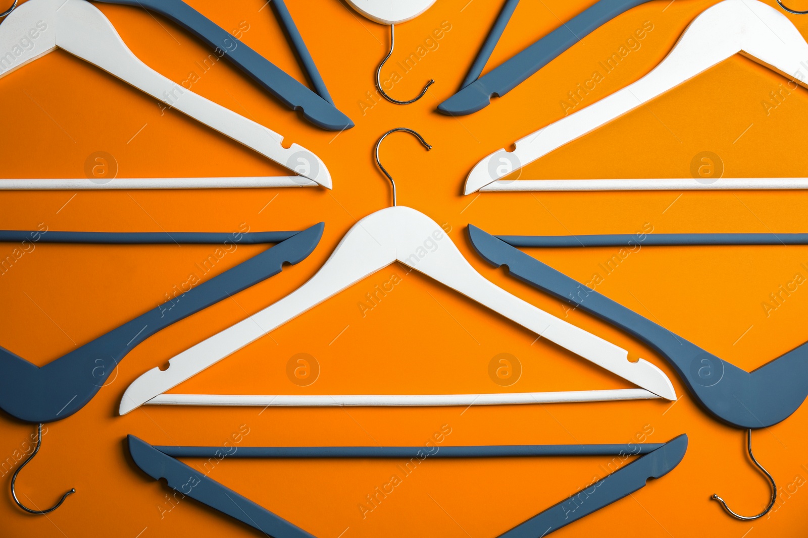 Photo of Flat lay composition with empty hangers on color background