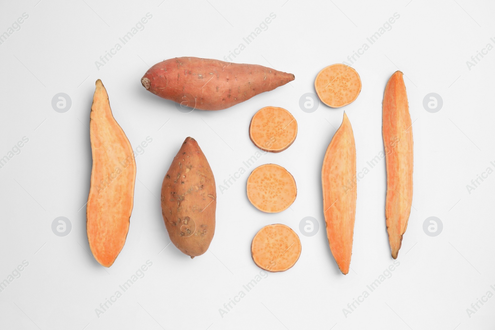 Photo of Cut and whole sweet potatoes on white background, top view