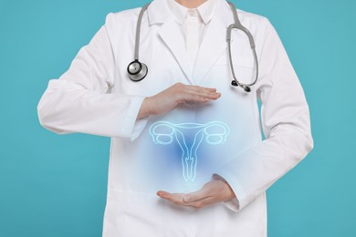 Doctor and illustration of female reproductive system on light blue background, closeup