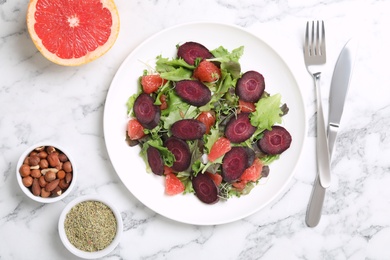 Photo of Delicious carrot salad served on white marble table, flat lay