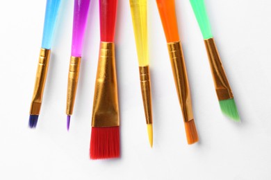 Photo of Set of different paintbrushes on white background, top view