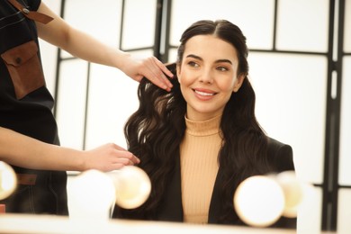 Photo of Hair styling. Professional hairdresser working with smiling client indoors, closeup