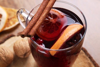 Photo of Aromatic mulled wine in glass cup on table, closeup