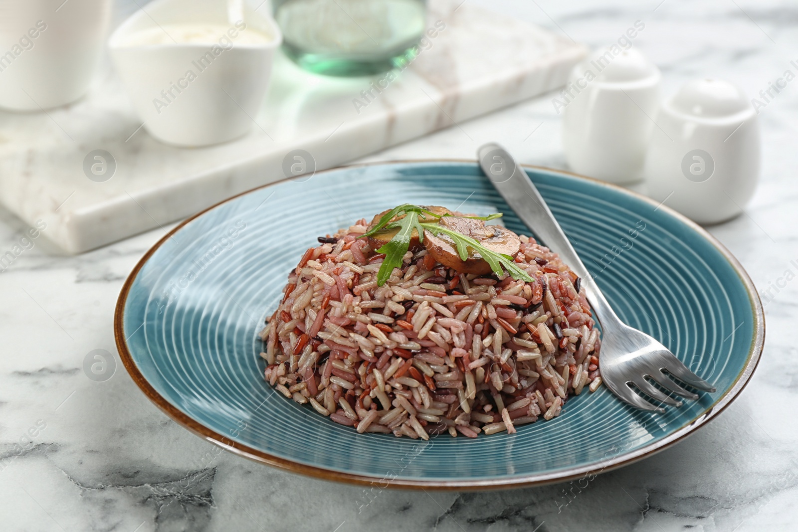 Photo of Tasty brown rice served on marble table