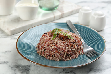 Photo of Tasty brown rice served on marble table