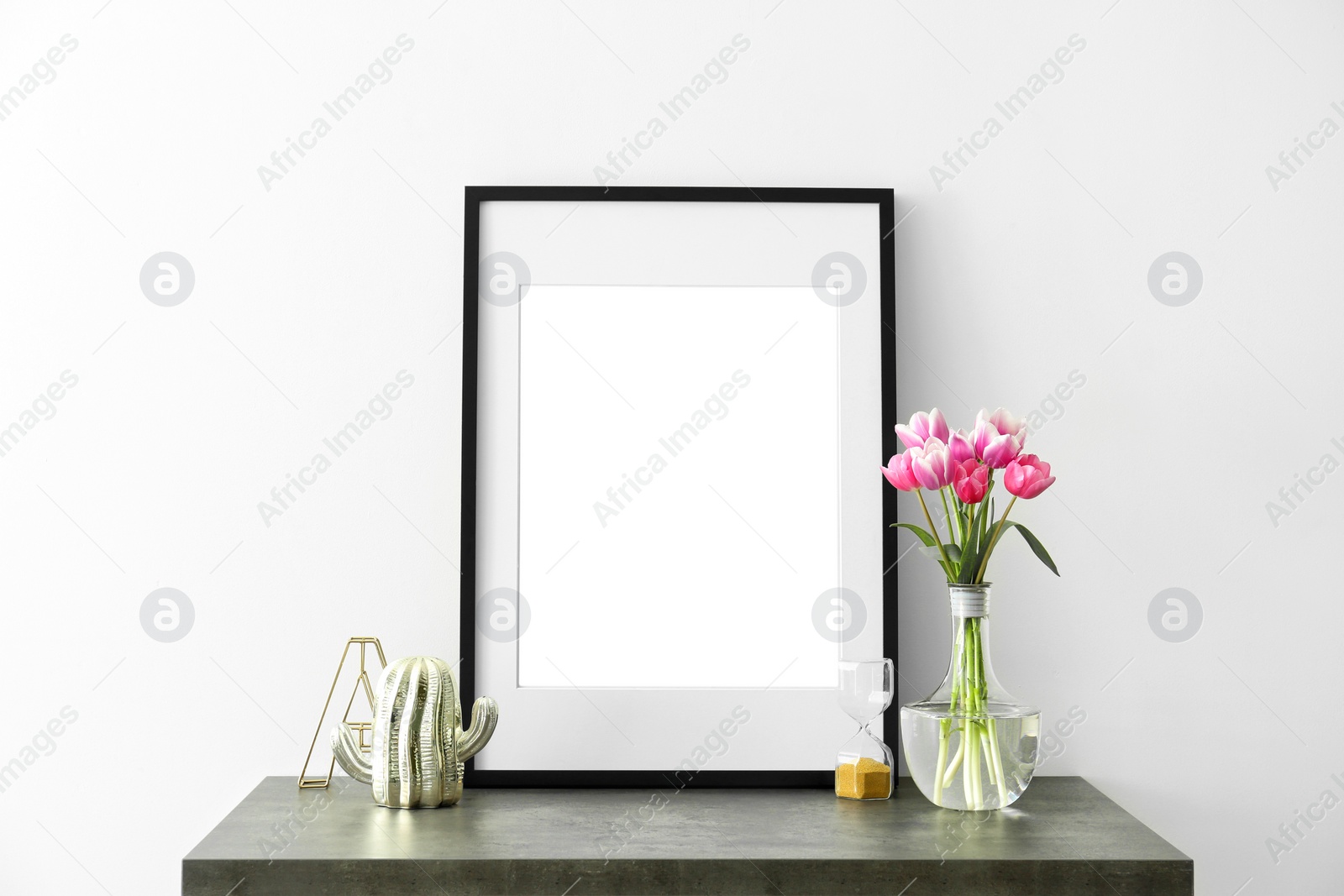 Photo of Mockup of blank frame and flowers on table