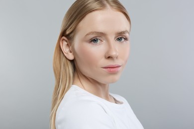 Portrait of beautiful young woman on grey background