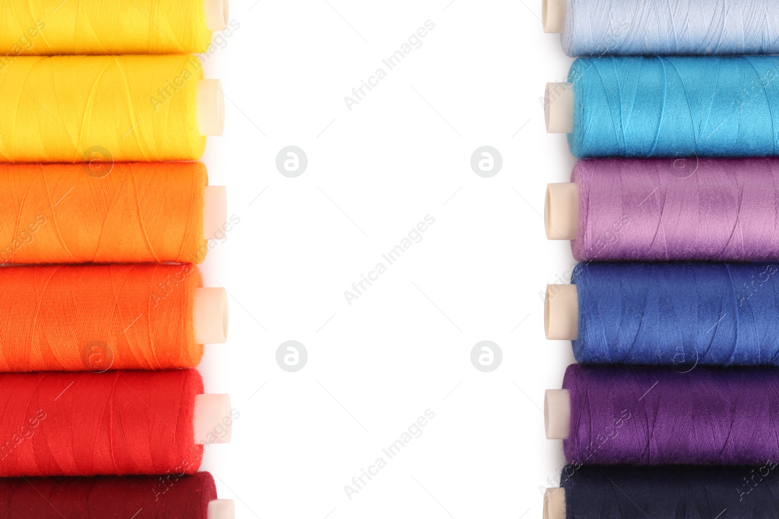 Photo of Frame of colorful sewing threads on white background, flat lay. Space for text