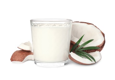 Photo of Glass of delicious vegan milk, coconut pieces and green leaf on white background