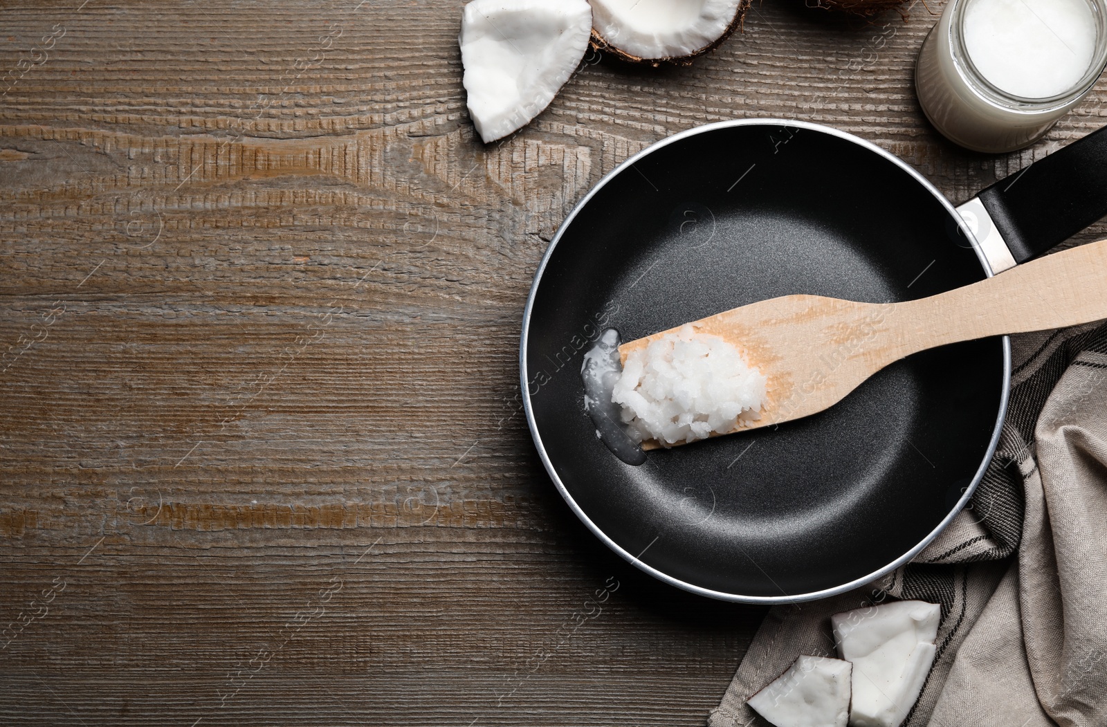 Photo of Flat lay composition with coconut oil and frying pan on wooden table, space for text. Healthy cooking