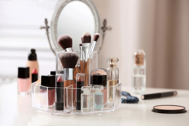 Photo of Makeup accessories and cosmetic products on table against blurred background