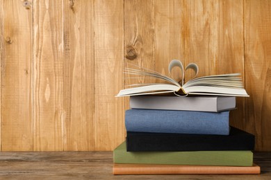 Photo of Stack of hardcover books on wooden table, space for text