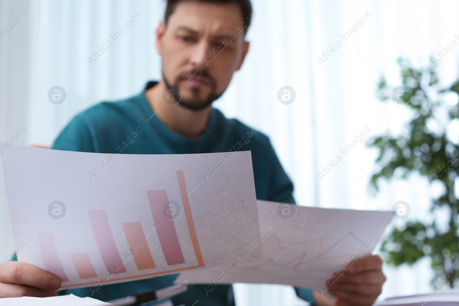 Photo of Man working with documents at table in office