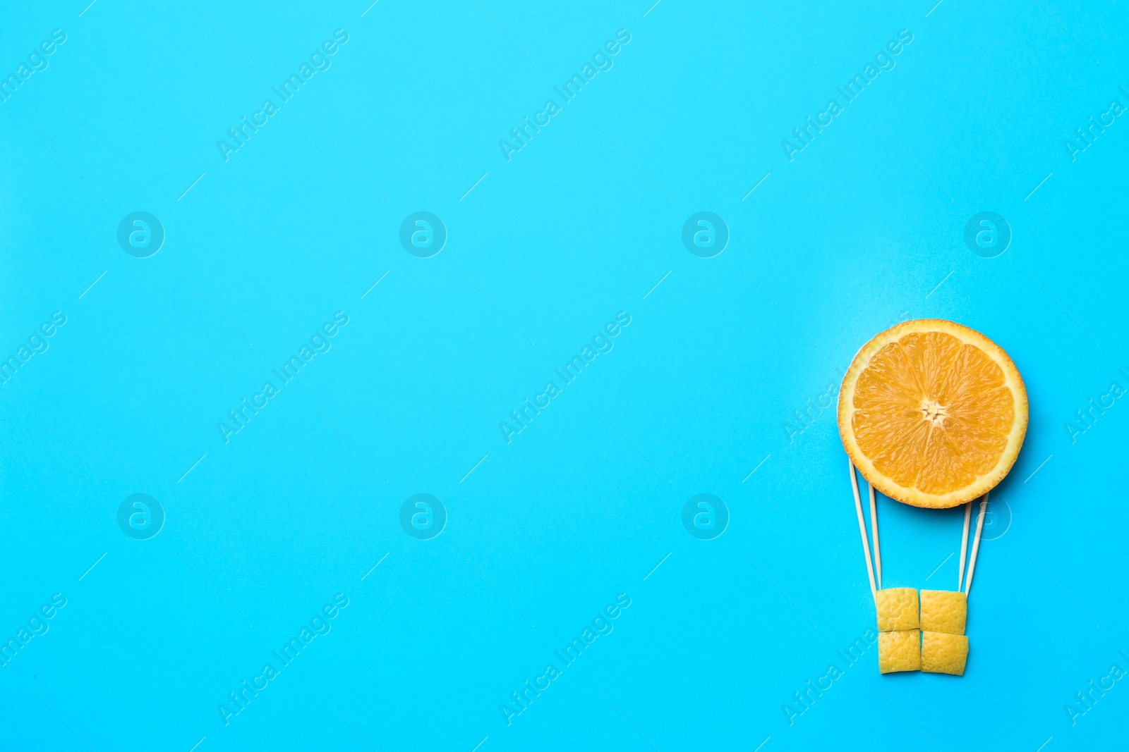 Photo of Hot air balloon made of orange on blue background, flat lay. Space for text