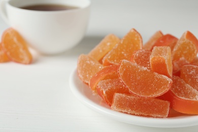 Tasty orange jelly candies on white table, closeup