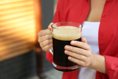 Photo of Young woman with cold kvass outdoors, closeup. Traditional Russian summer drink