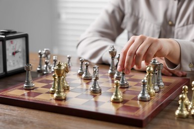 Photo of Woman playing chess during tournament at table, closeup