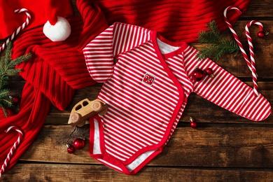 Photo of Flat lay composition with Christmas baby clothes on wooden background