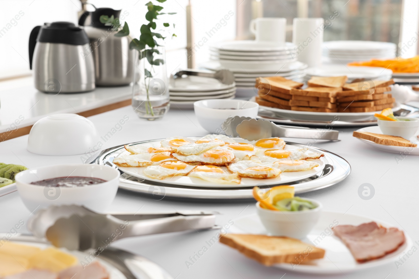 Photo of Clean dishware and different meals for breakfast on white table indoors. Buffet service