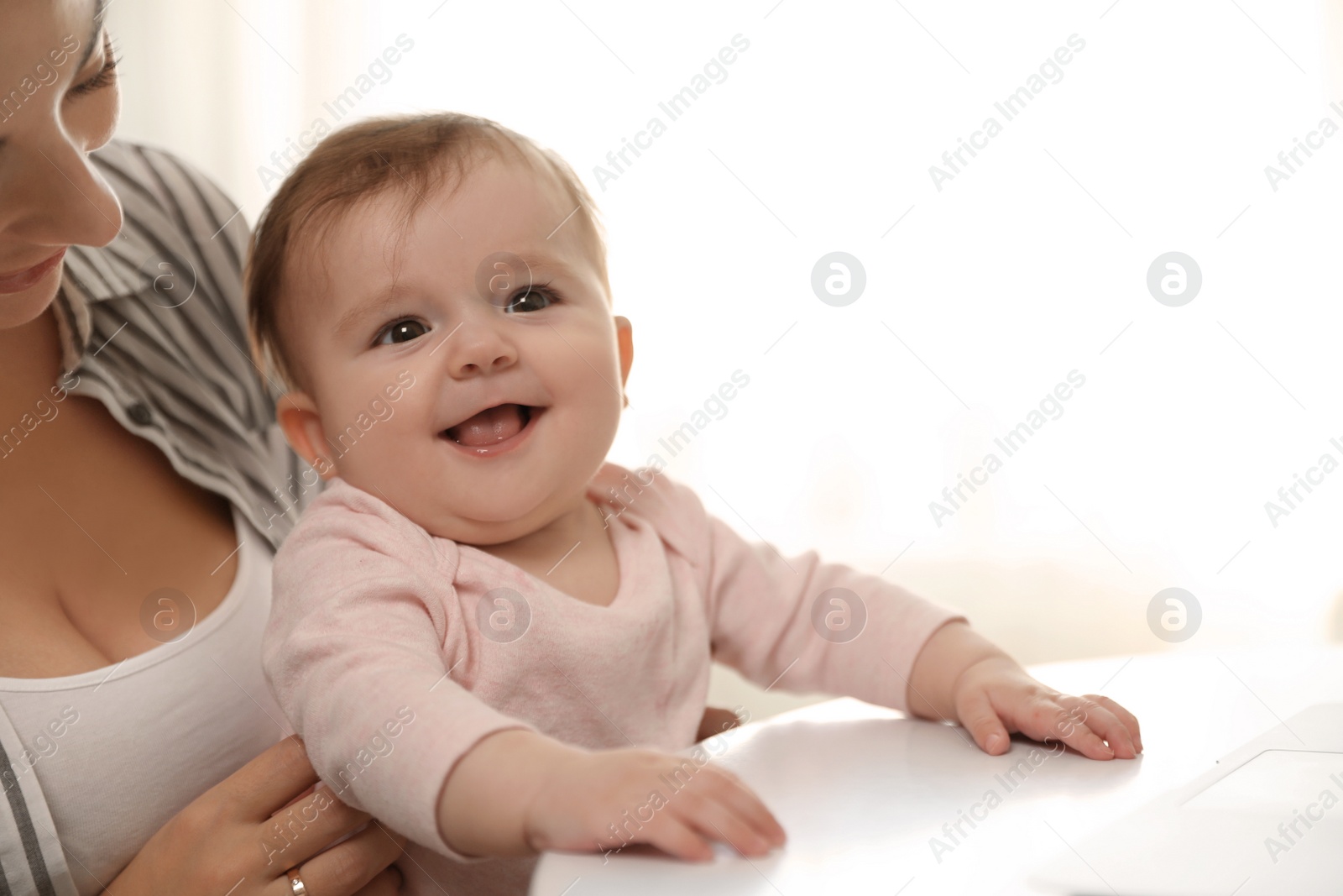 Photo of Young woman with her cute baby at home