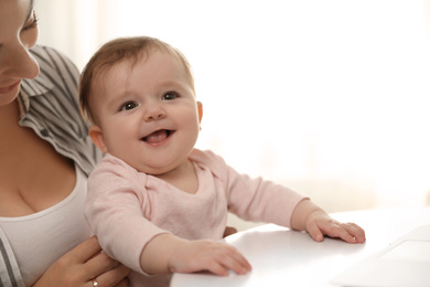 Photo of Young woman with her cute baby at home