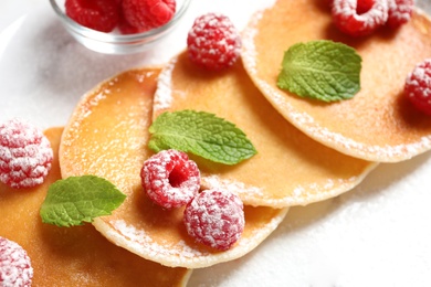 Tasty pancakes with berries and mint on plate, closeup