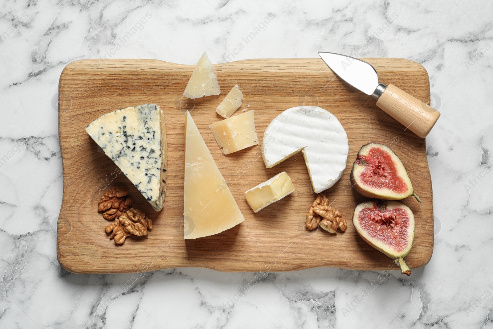 Photo of Different delicious cheeses served on marble table, top view