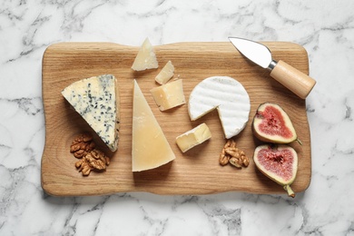 Different delicious cheeses served on marble table, top view