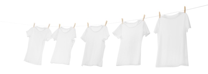 Photo of Many t-shirts drying on washing line isolated on white, low angle view