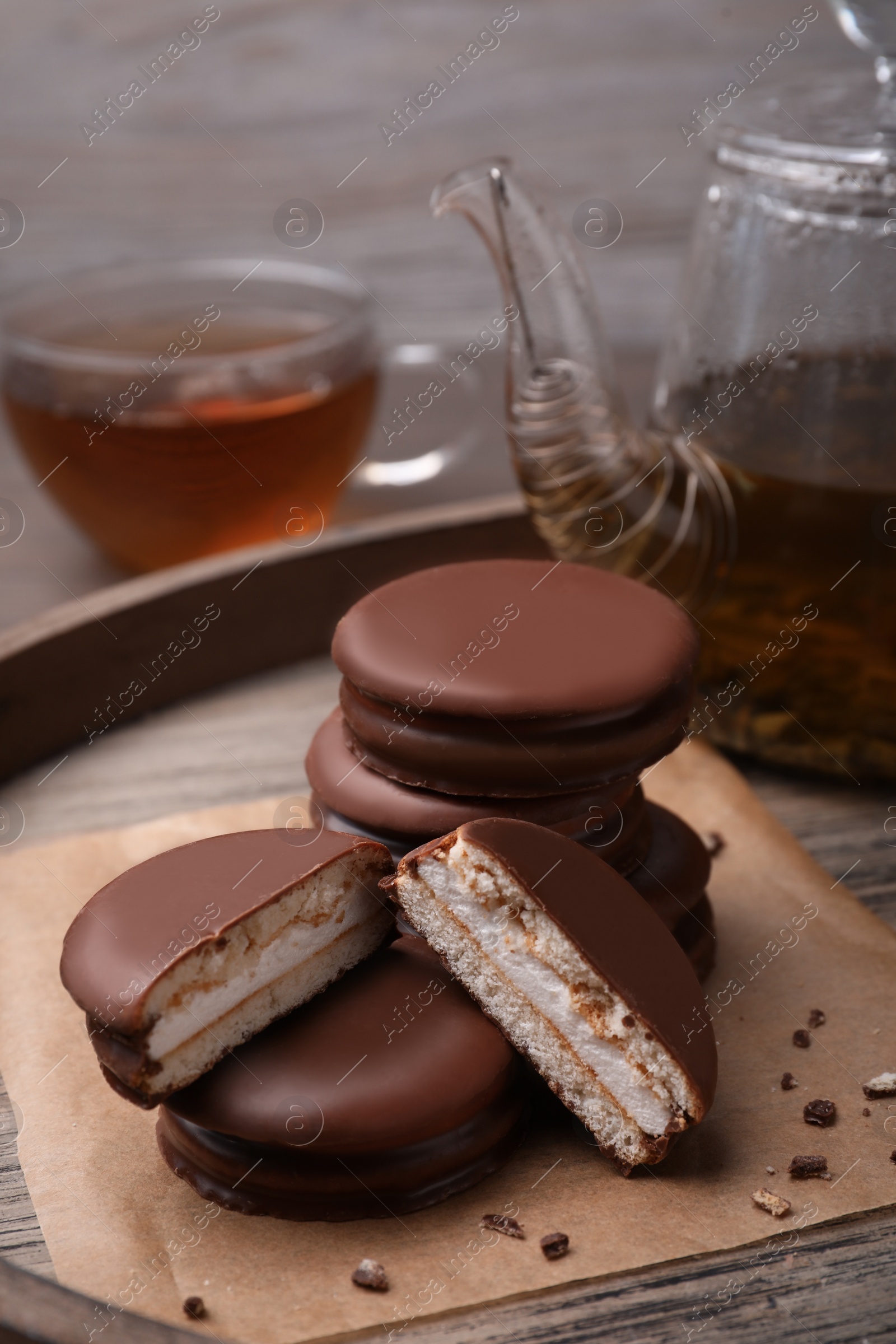 Photo of Tasty choco pies and tea on wooden tray