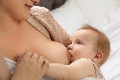 Woman breastfeeding her little baby at home