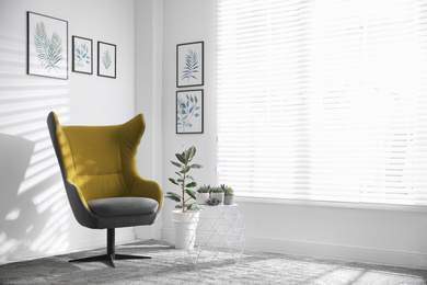 Photo of Comfortable armchair near white wall in light room