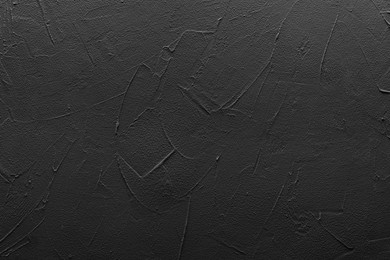 Black textured surface as background, top view