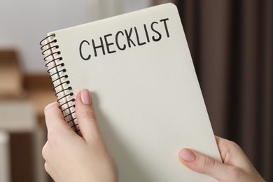 Photo of Woman holding notebook with inscription Checklist, closeup