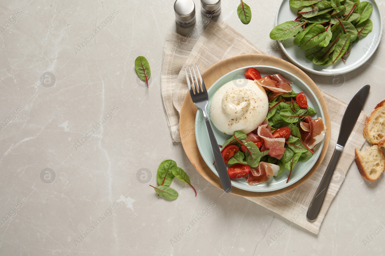 Photo of Delicious burrata salad served on light grey marble table, flat lay. Space for text