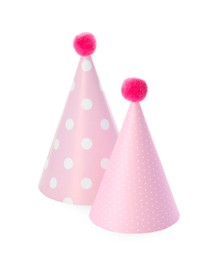 Two pink party hats with pompoms isolated on white