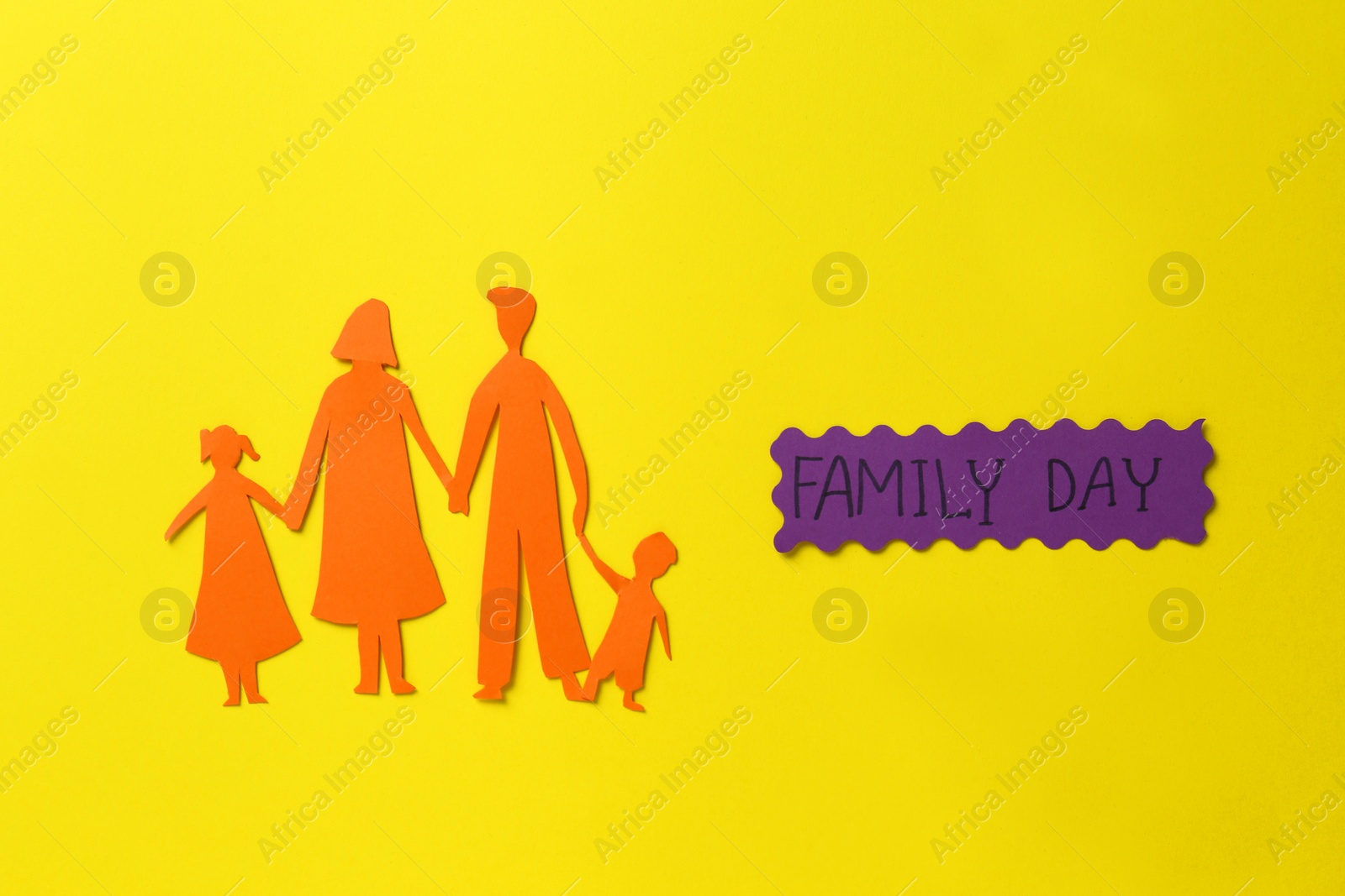 Photo of Card with text Family Day and paper cutout on yellow background, flat lay