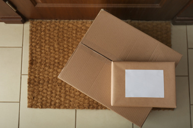 Photo of Parcels on rug near door, flat lay. Delivery service