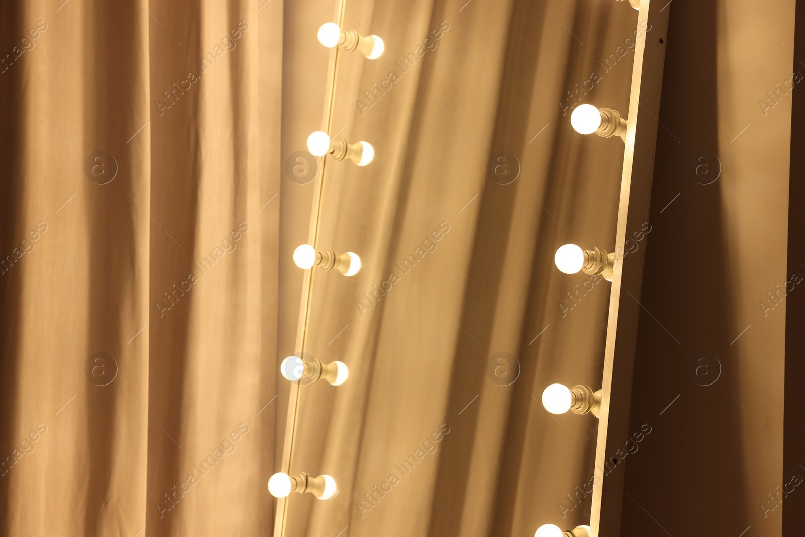 Photo of Modern mirror with light bulbs in makeup room, closeup