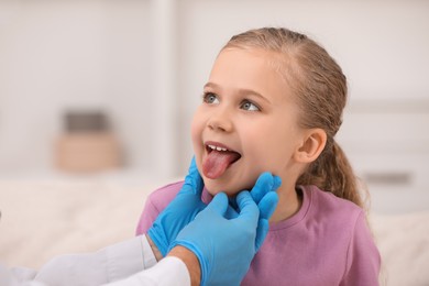 Photo of Doctor examining girl`s oral cavity indoors, closeup
