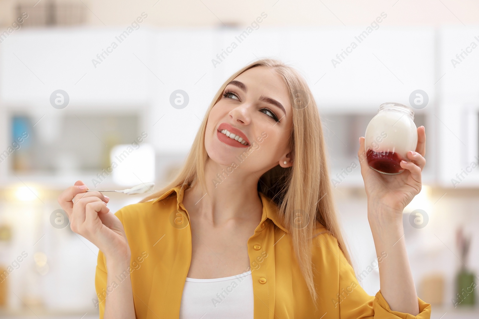 Photo of Young woman with yogurt on blurred background