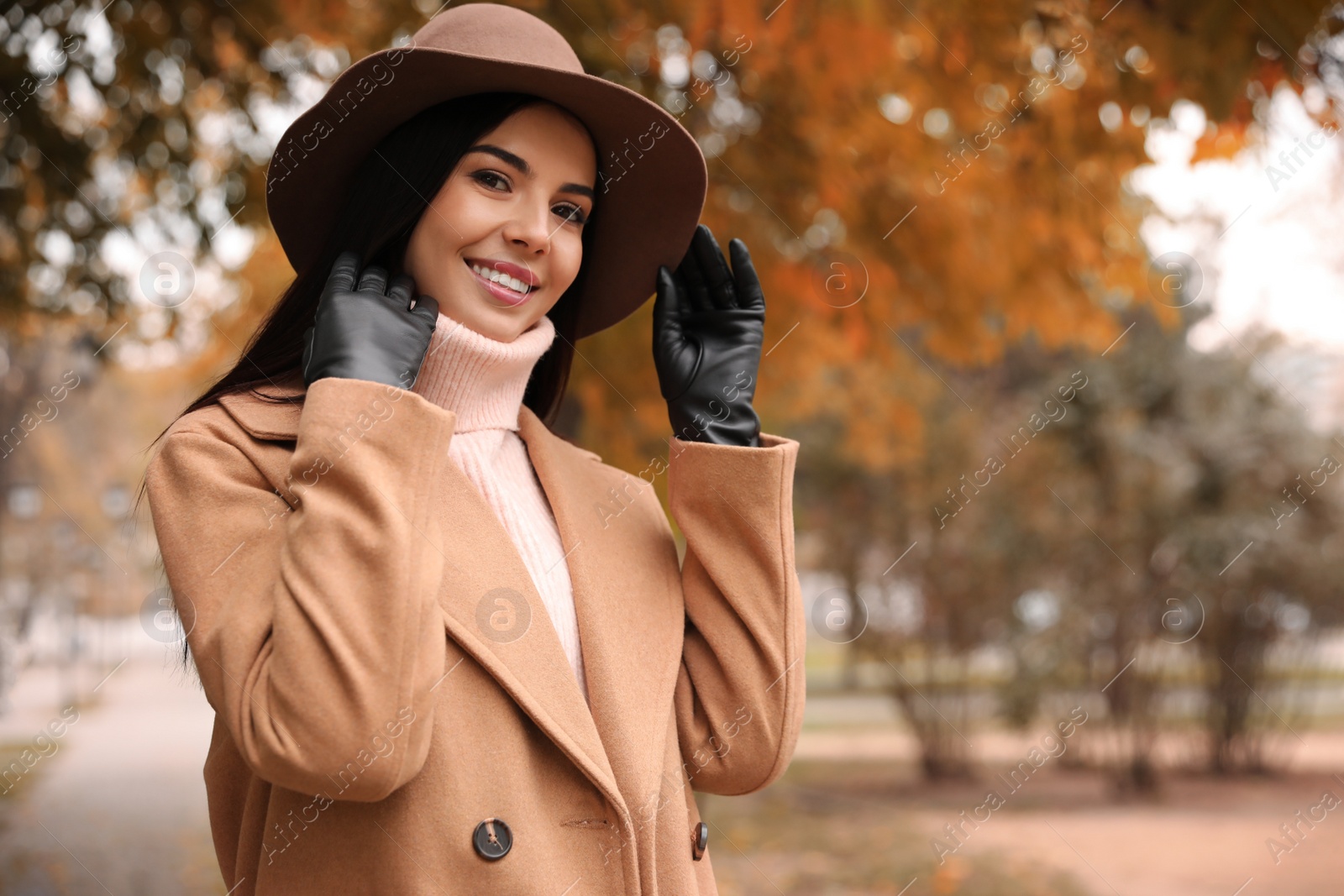 Photo of Young woman wearing stylish clothes in autumn park, space for text