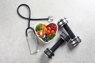 Photo of Flat lay composition with bowl of products for heart-healthy diet on grey background