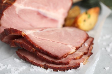 Photo of Cut delicious ham with salt on table, closeup